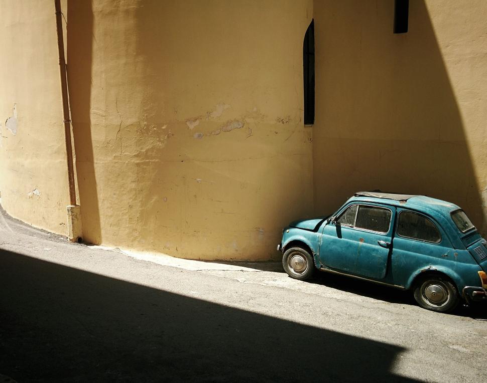 Free Image of Small Blue Car Parked in Front of Building 