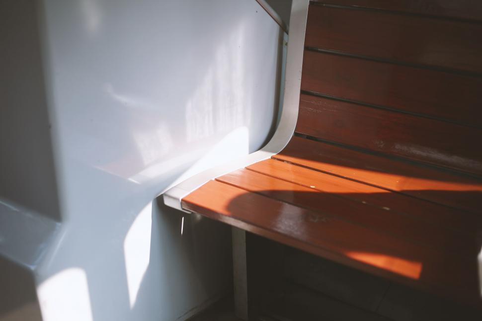 Free Image of Wooden Bench Next to White Wall 