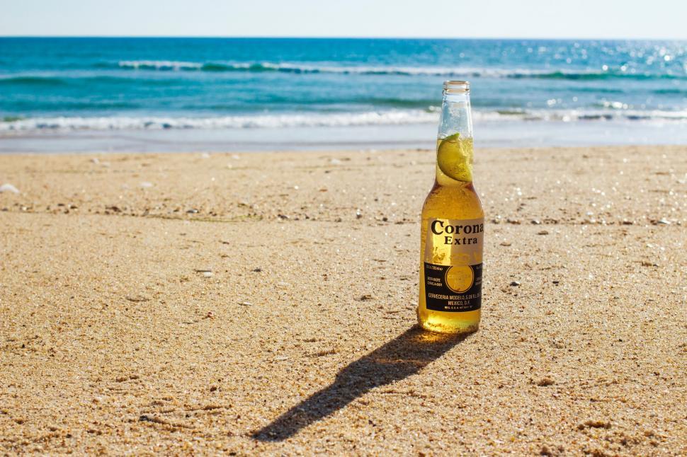 Free Image of Bottle of Beer on Sandy Beach 