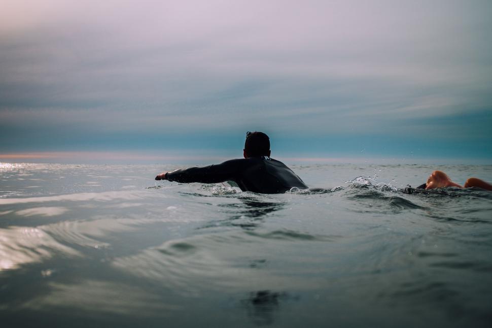 Free Image of Person Swimming in Ocean With Sky Background 