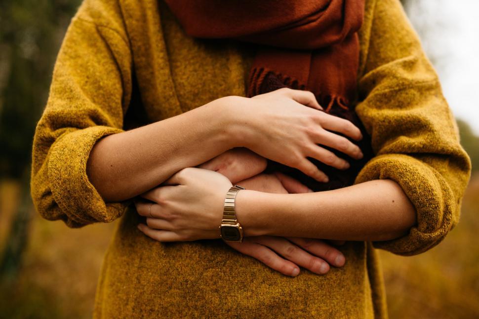 Free Image of Woman in Yellow Sweater Holding Hands Together 