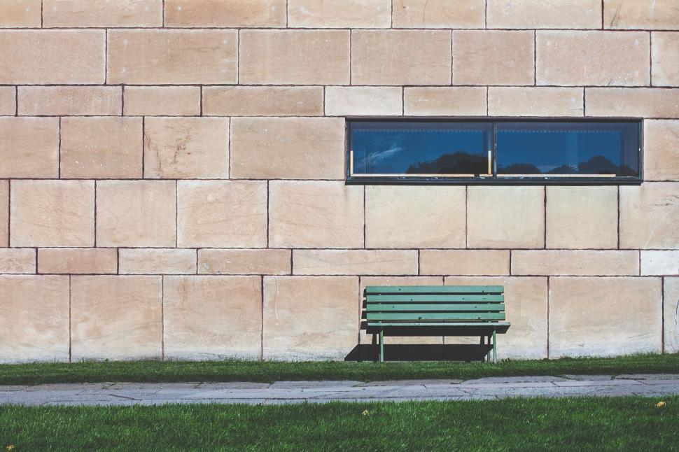 Free Image of Green Bench in Front of Brick Wall 