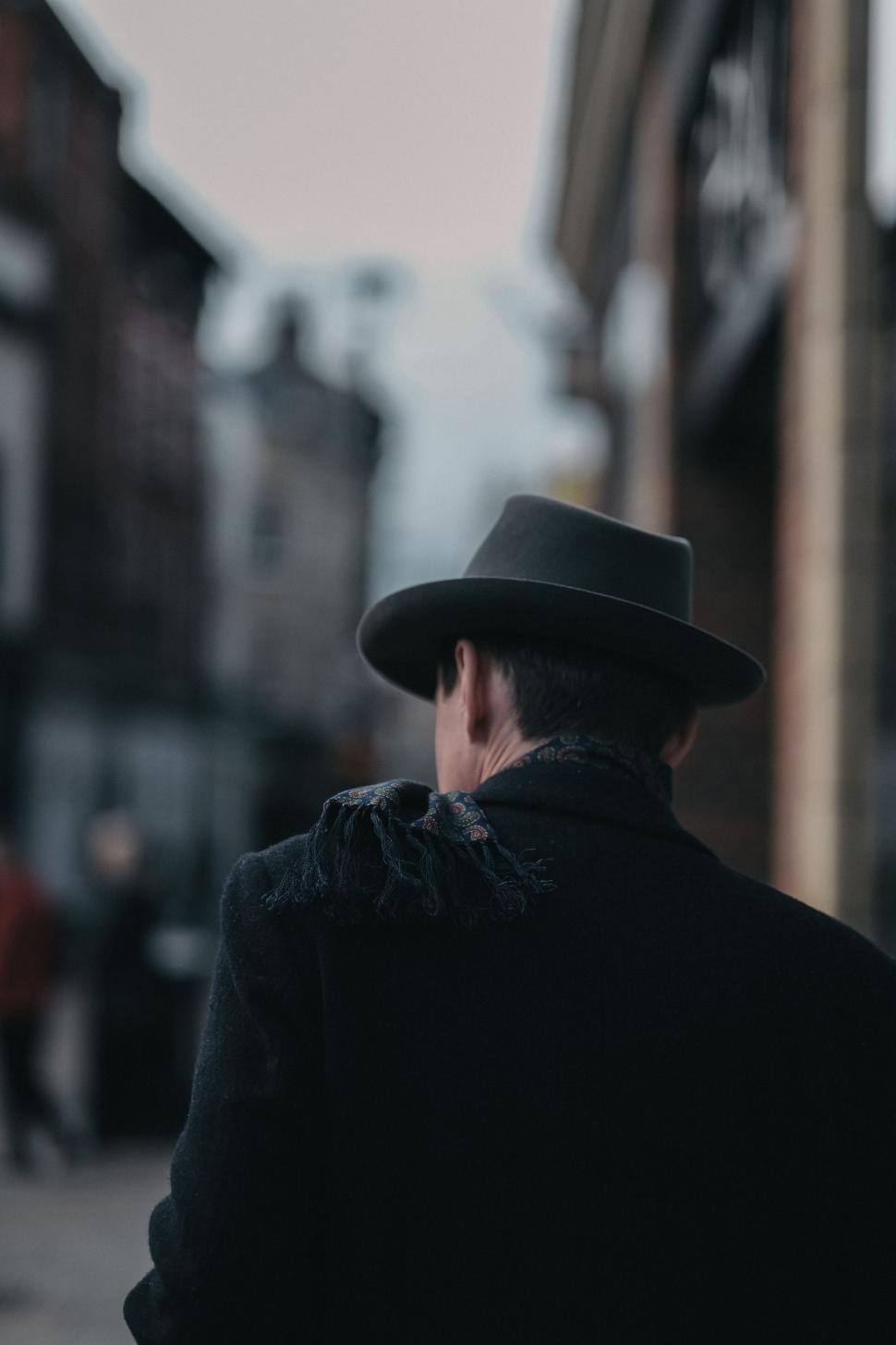 Free Image of Man in Hat and Coat Walking Down Street 