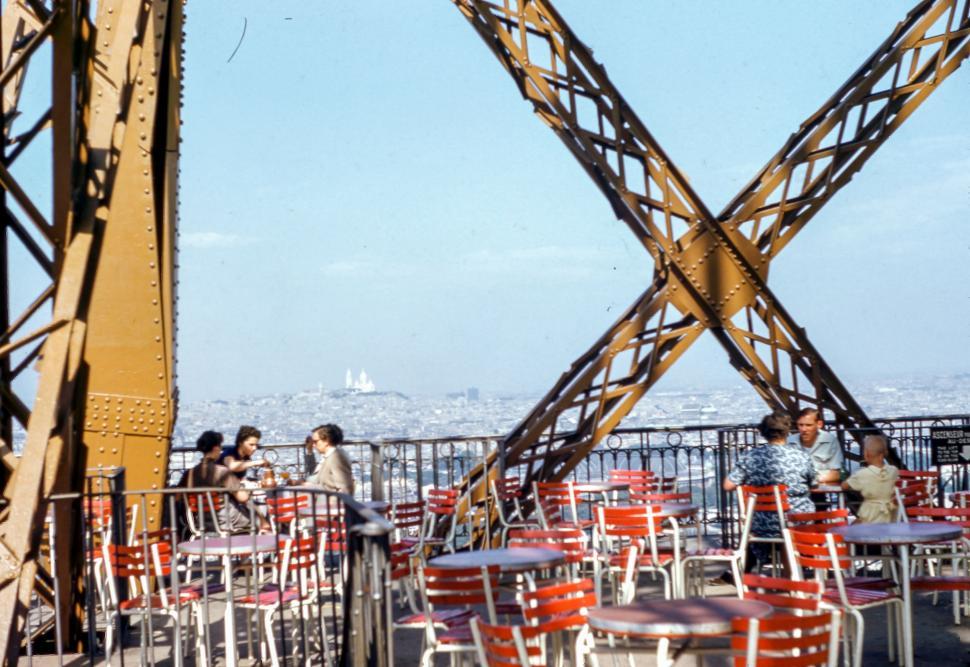 Free Image of Group of People Sitting at Tables on Bridge 