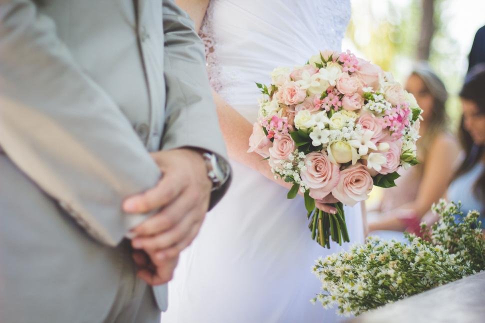 Free Image of A Close Up of a Bride and Groom Holding Hands 