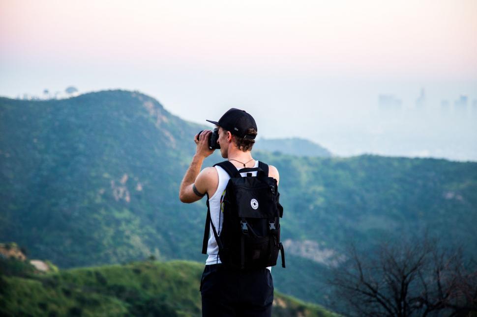 Free Image of Man Taking Photo of Mountain Range 