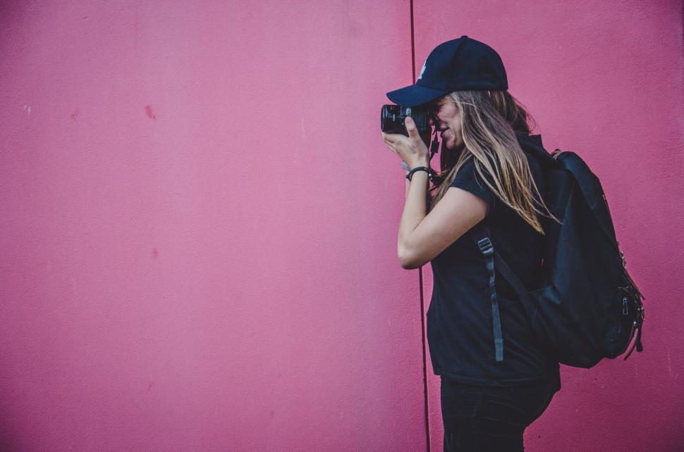 Free Image of Woman With Long Hair Wearing Hat Holding Camera 