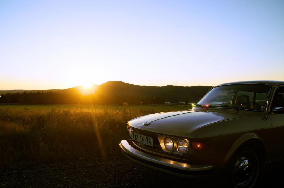 Free Image of A Car Parked in a Field at Sunset 