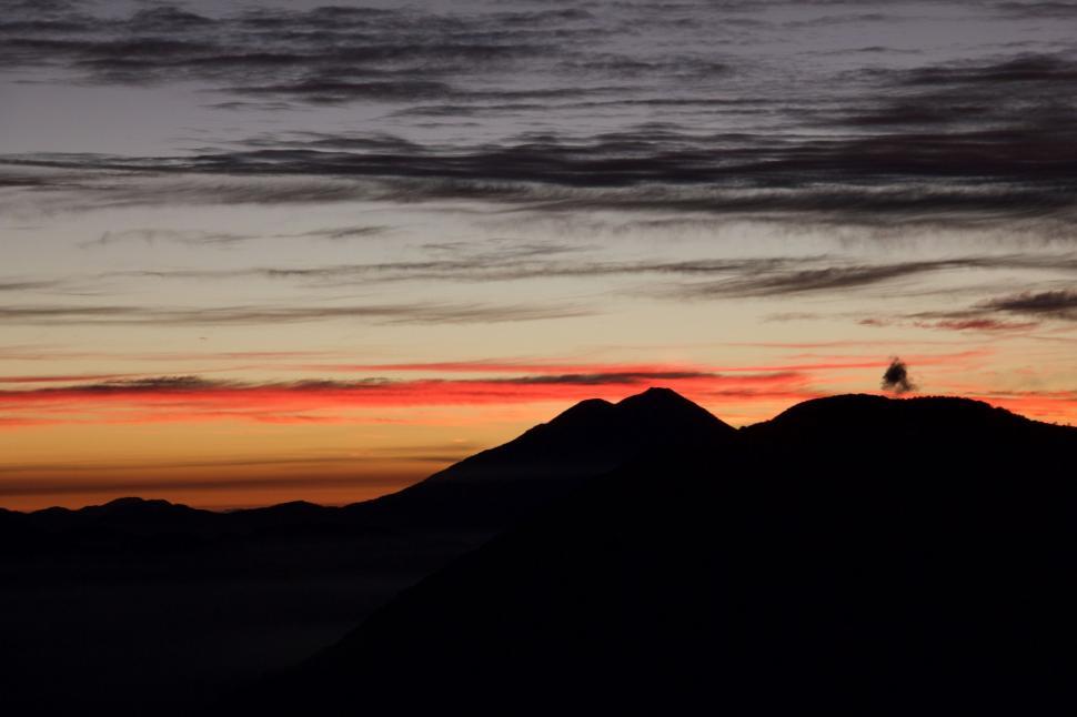 Free Image of Bird Perched on Mountain Peak at Sunset 