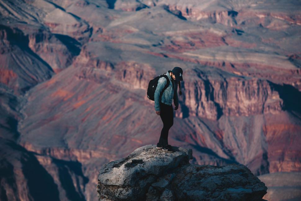 Free Image of Man Standing on Top of a Mountain With a Backpack 