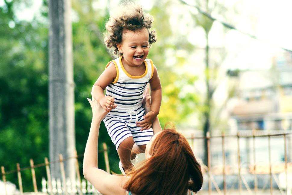 Free Image of Woman Holding Baby Up in the Air 