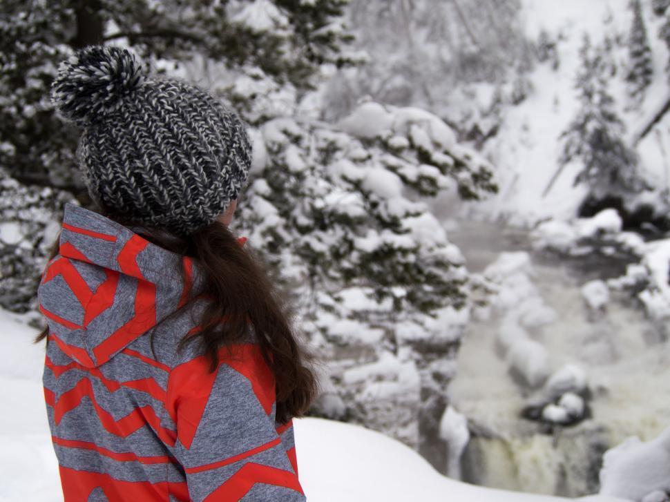 Free Image of Woman Standing in Snow, Looking at Stream 