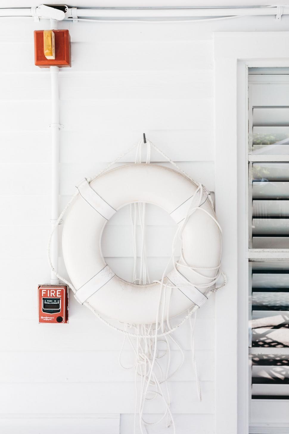 Free Image of Life Preserver Hanging on White Wall 