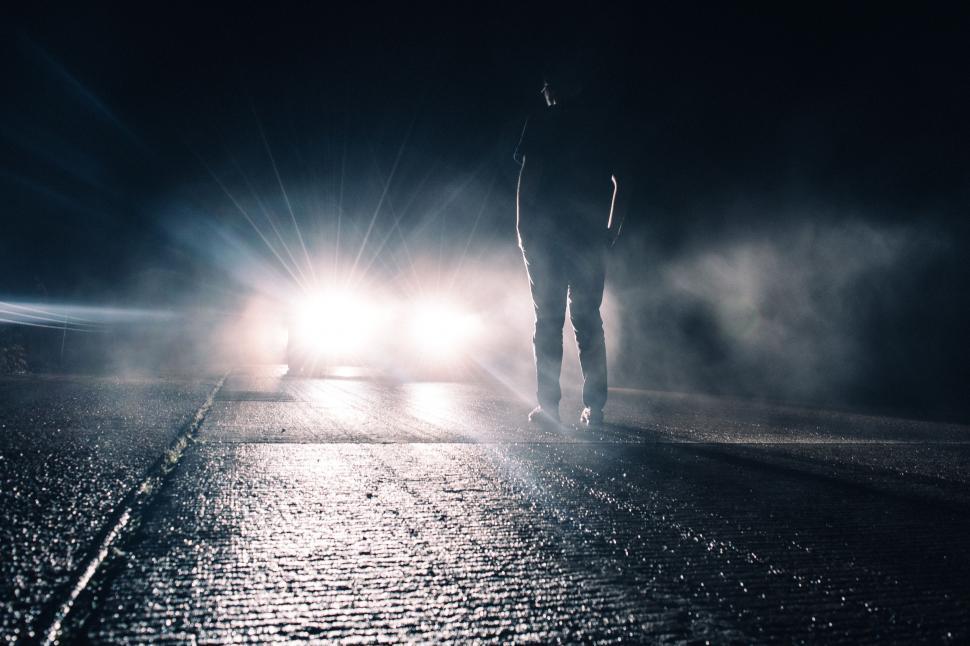Free Image of Man Standing in Middle of Street at Night 