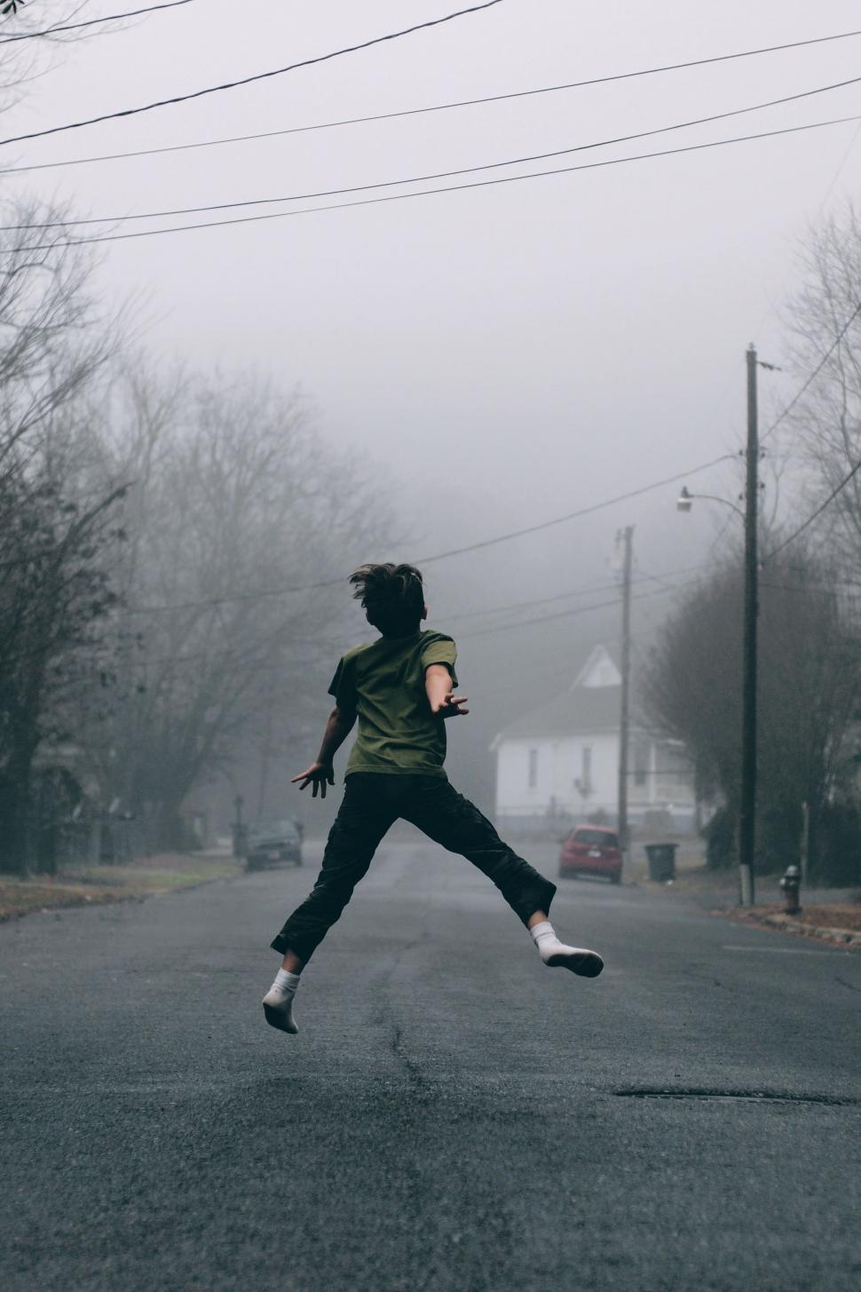 Free Image of Person Jumping in the Middle of a Street 