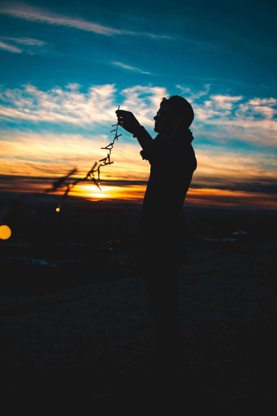 Free Image of Person Holding Camera Silhouette at Sunset 