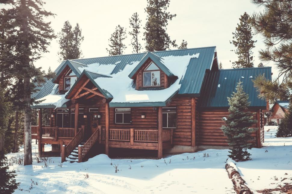 Free Image of Snow-Covered Log Cabin in Woodlands 
