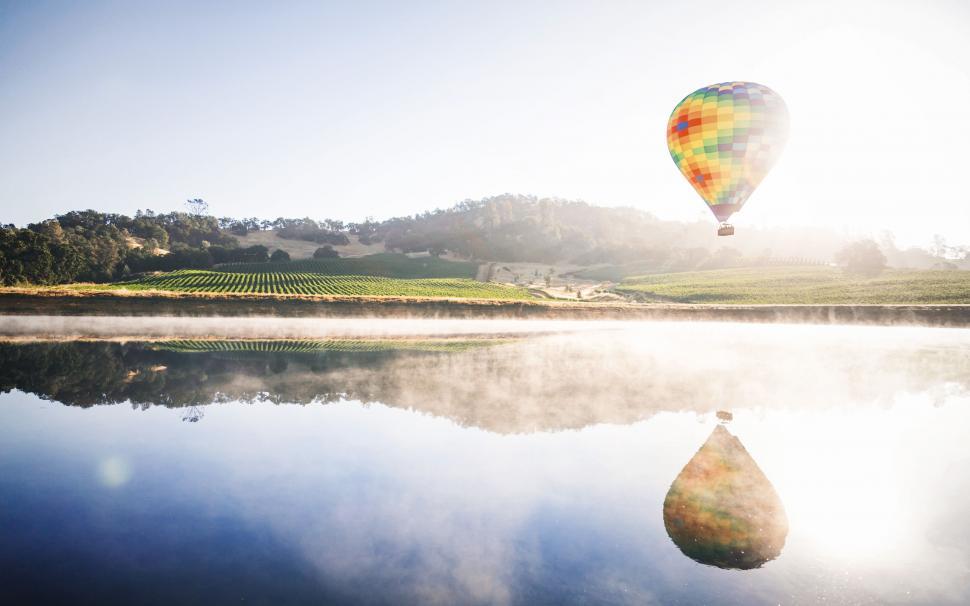 Free Image of Hot Air Balloon Flying Over Lake 