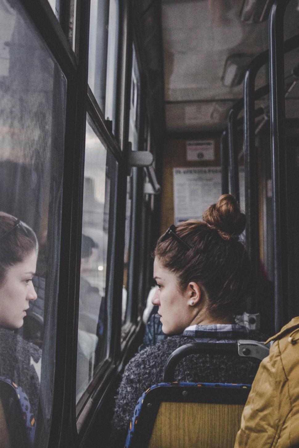 Free Image of Two Women Sitting on a Bus Looking Out the Window 