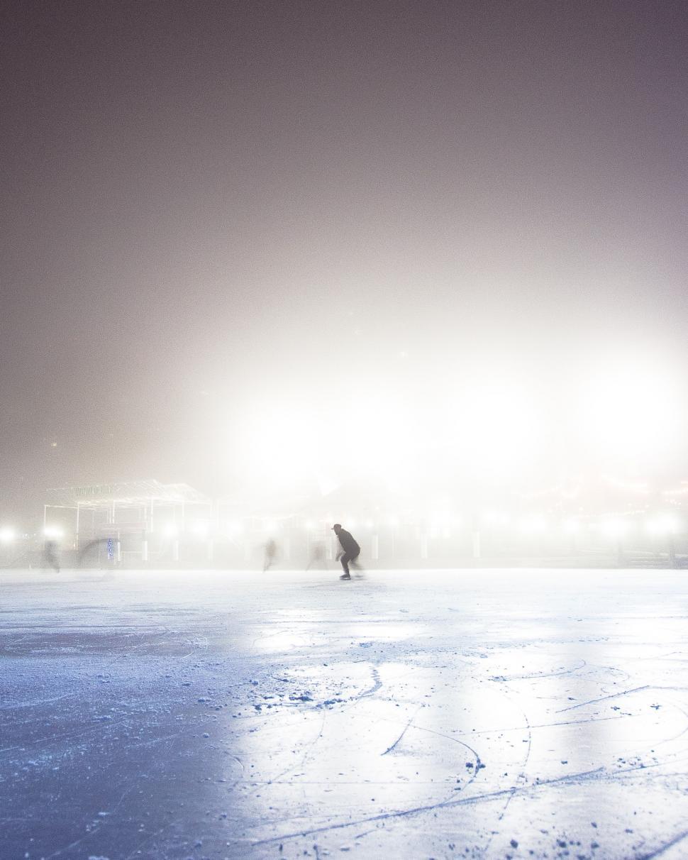 Free Image of Group of People Skating on Frozen Lake at Night 