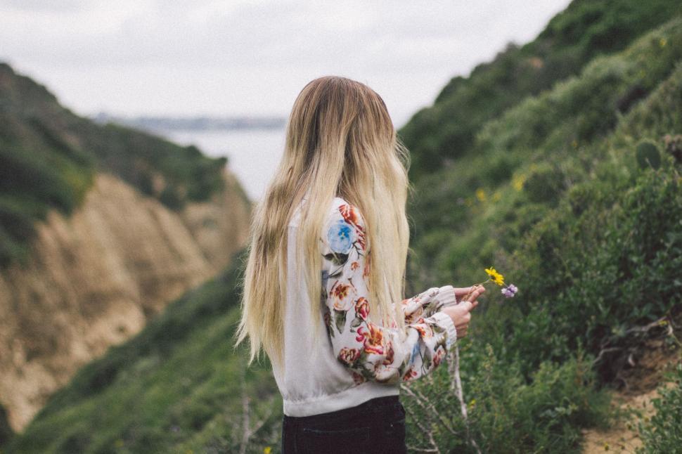 Free Image of Woman With Long Blonde Hair Walking Down a Hill 