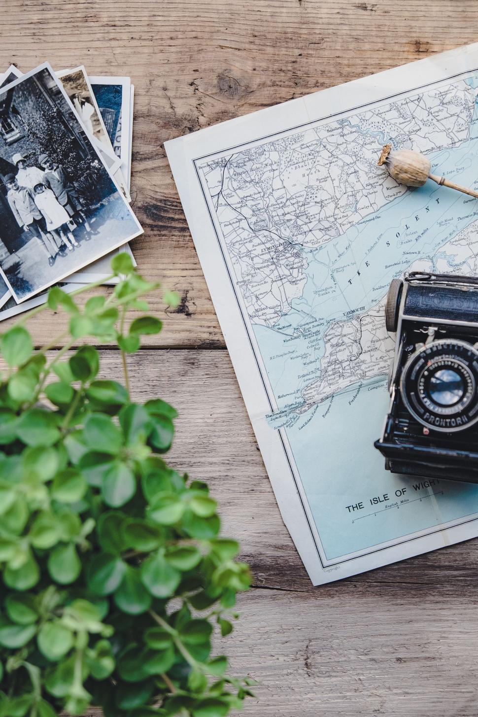 Free Image of Vintage Camera on Map Beside Potted Plant 