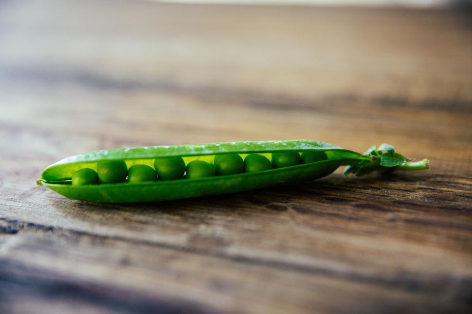Free Image of Green Pea Pod on Wooden Table 