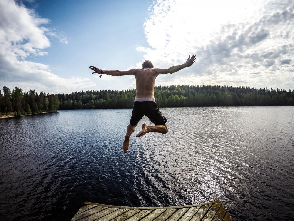 Free Image of Man Jumping off Dock Into Lake 