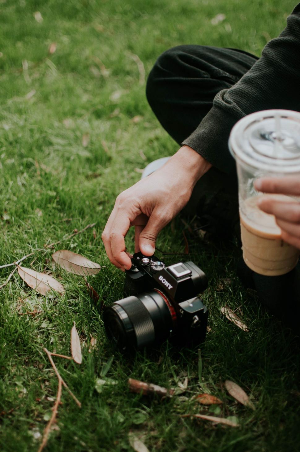 Free Image of Person Holding Camera and Cup of Coffee 