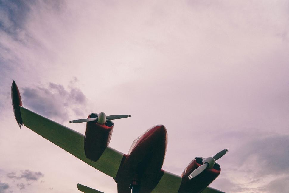 Free Image of Large Propeller Plane Flying Through Cloudy Sky 
