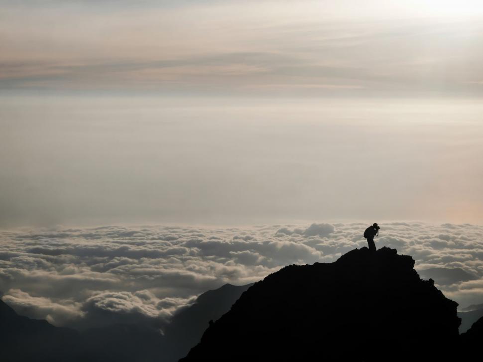 Free Image of Person Standing on Mountain Top Above Clouds 