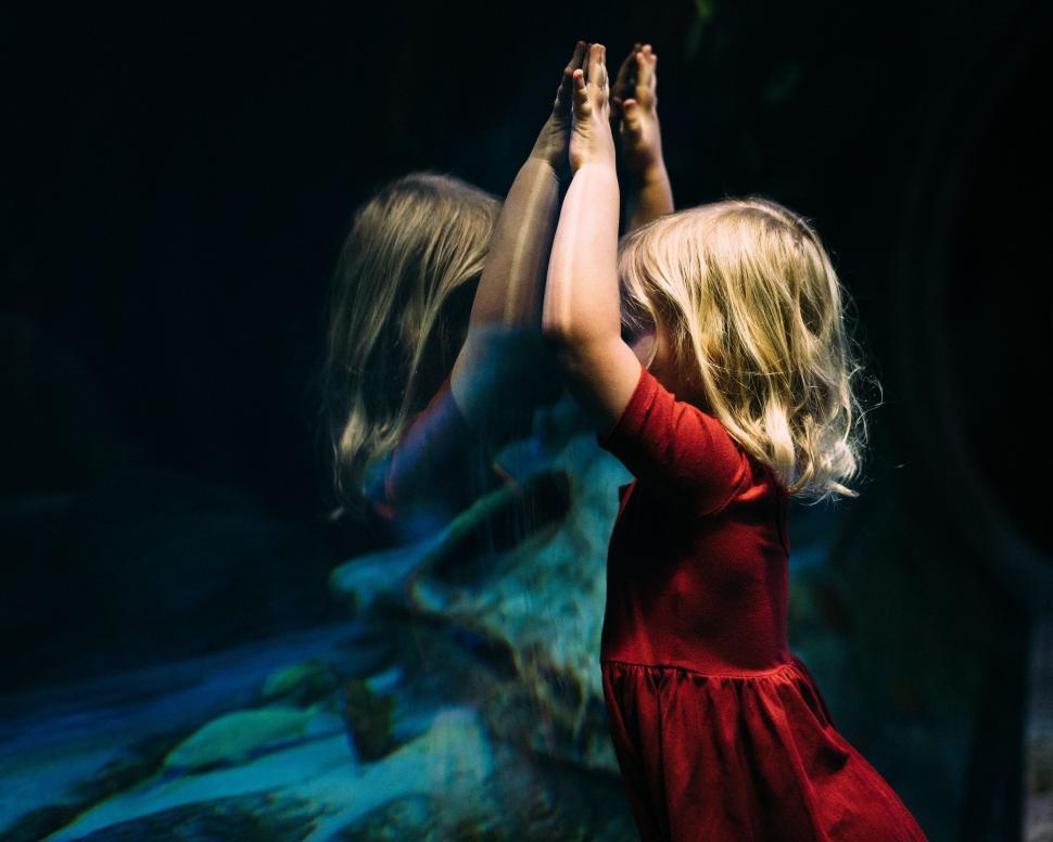 Free Image of Little Girl in Red Dress Reaching for Something 