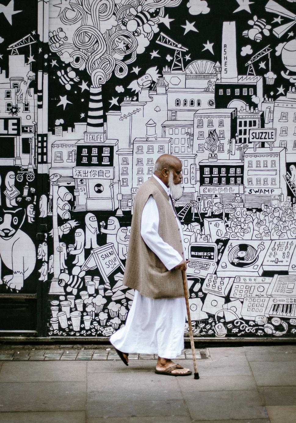 Free Image of Man Standing in Front of Mural Wall 