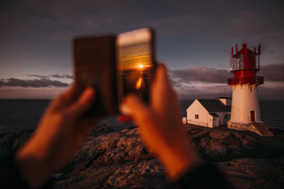 Free Image of Person Capturing Lighthouse With Cell Phone 