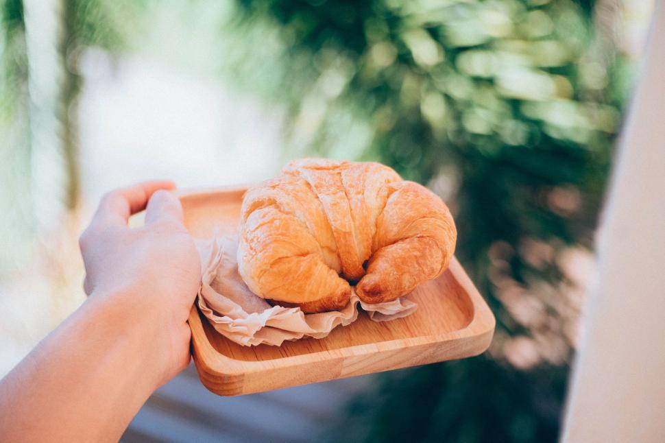 Free Image of Person Holding Wooden Tray With Croissant 