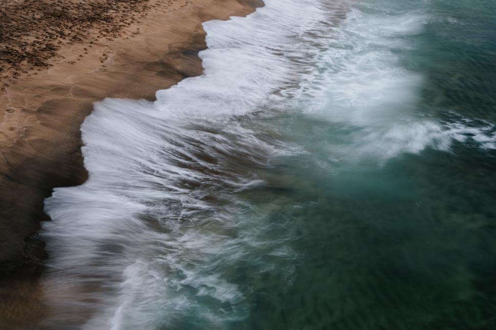 Free Image of Aerial View of Beach With Waves Crashing 