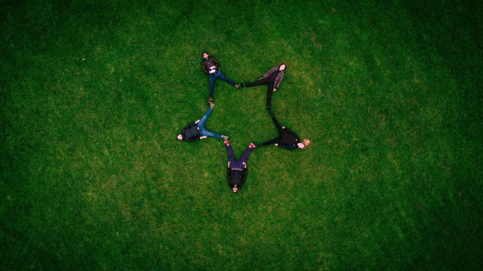 Free Image of Group of People Laying on Lush Green Field 