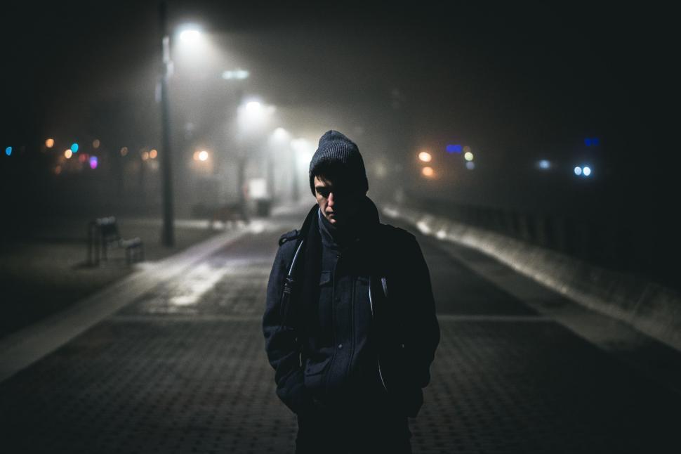 Free Image of Man Standing on Sidewalk at Night 