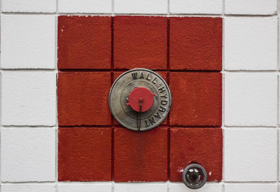 Free Image of Red and White Tiled Wall With Metal Button 