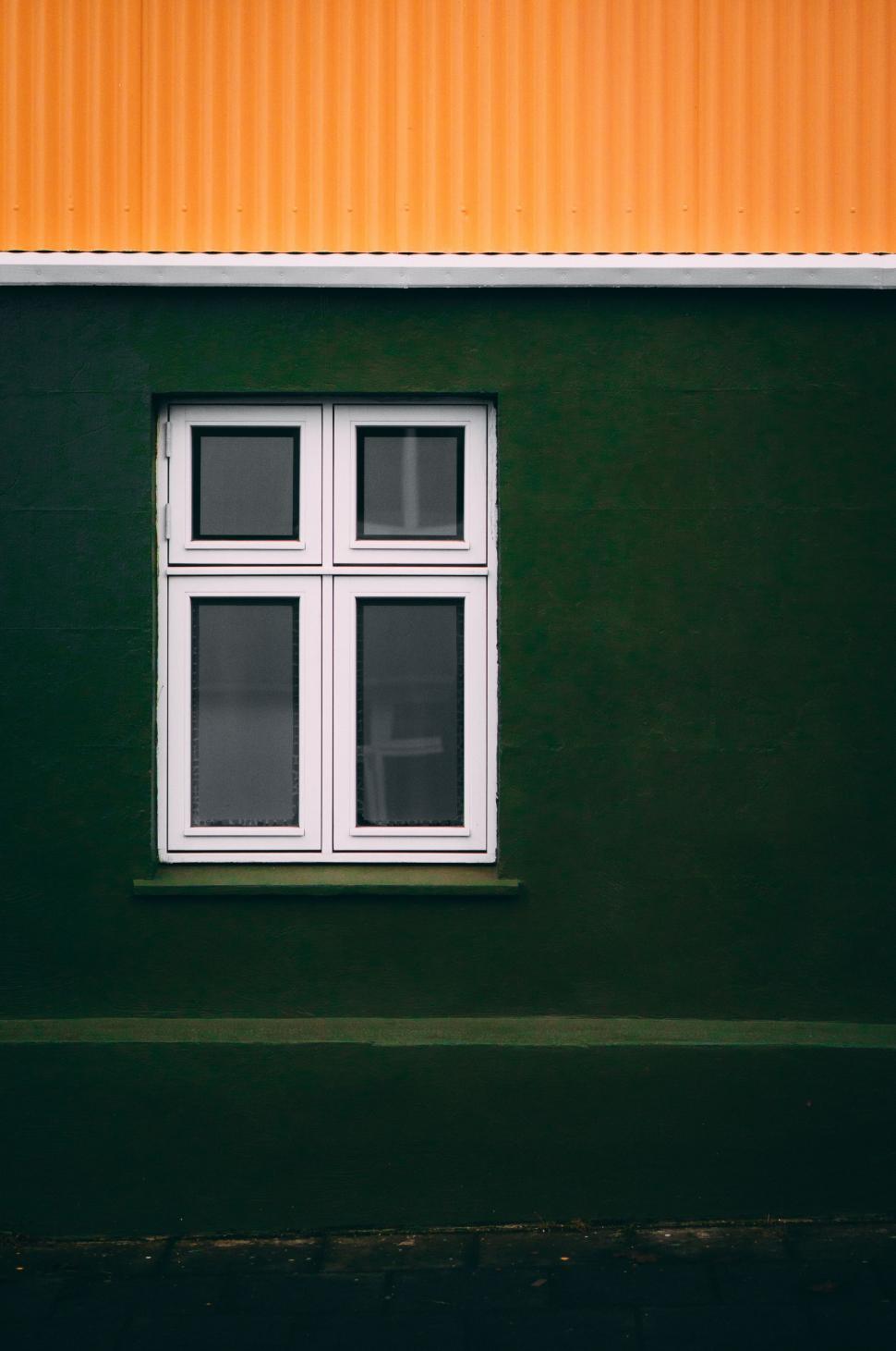 Free Image of Green Building With White Window and Yellow Wall 