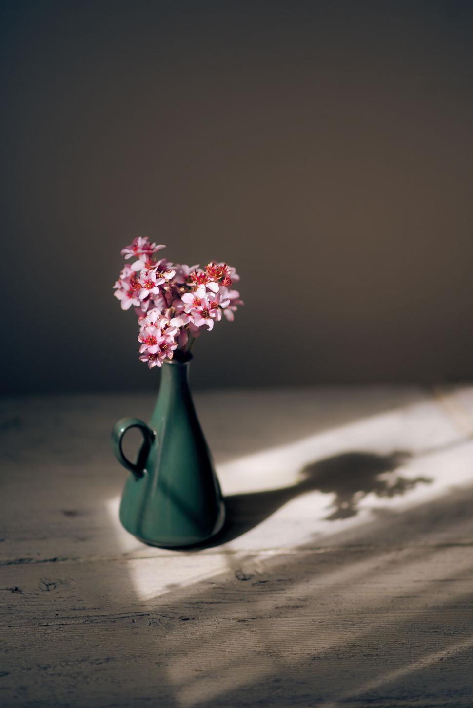 Free Image of Green Vase With Pink Flowers on Table 