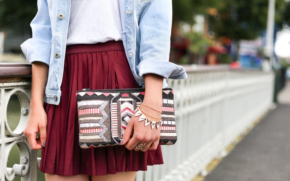 Free Image of Woman in Red Skirt Holding Purse 
