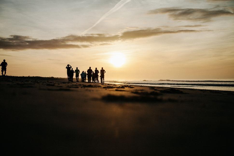 Free Image of Group of People Standing on Top of Sandy Beach 