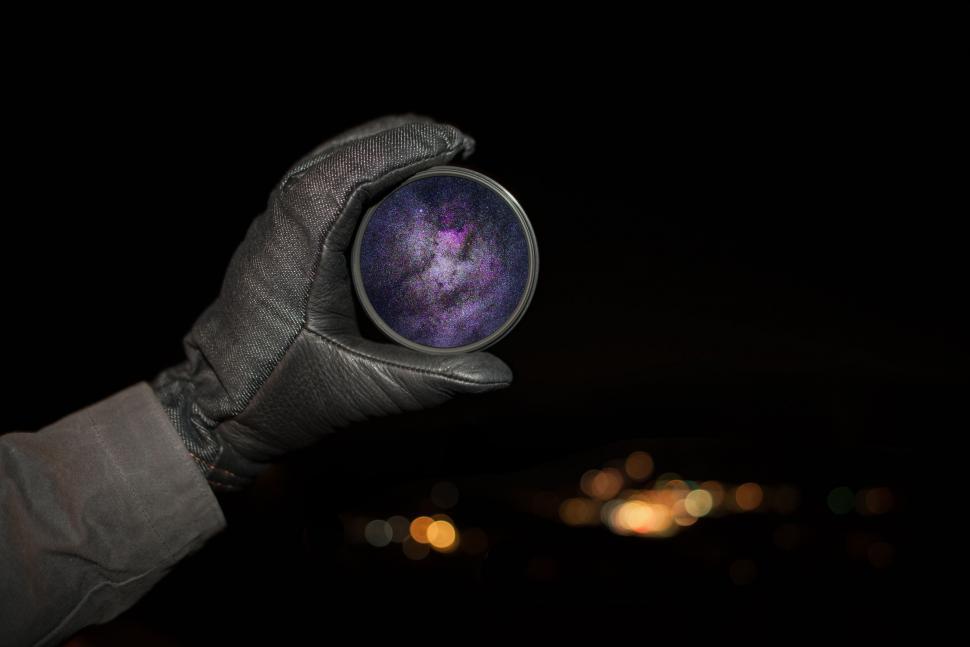 Free Image of Hand Holding Purple Object in the Dark 