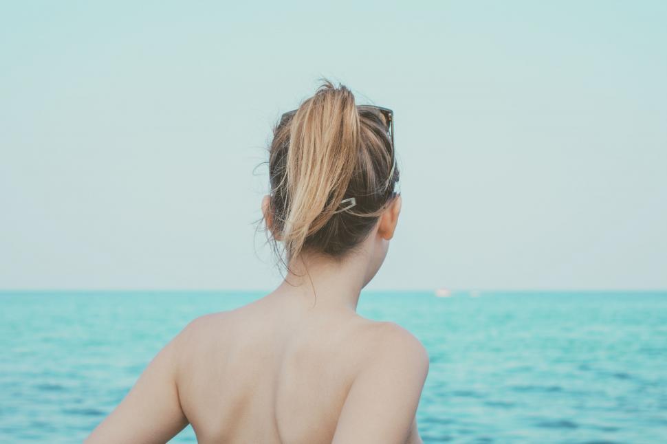 Free Image of Woman Sitting on Boat, Looking Out at Ocean 