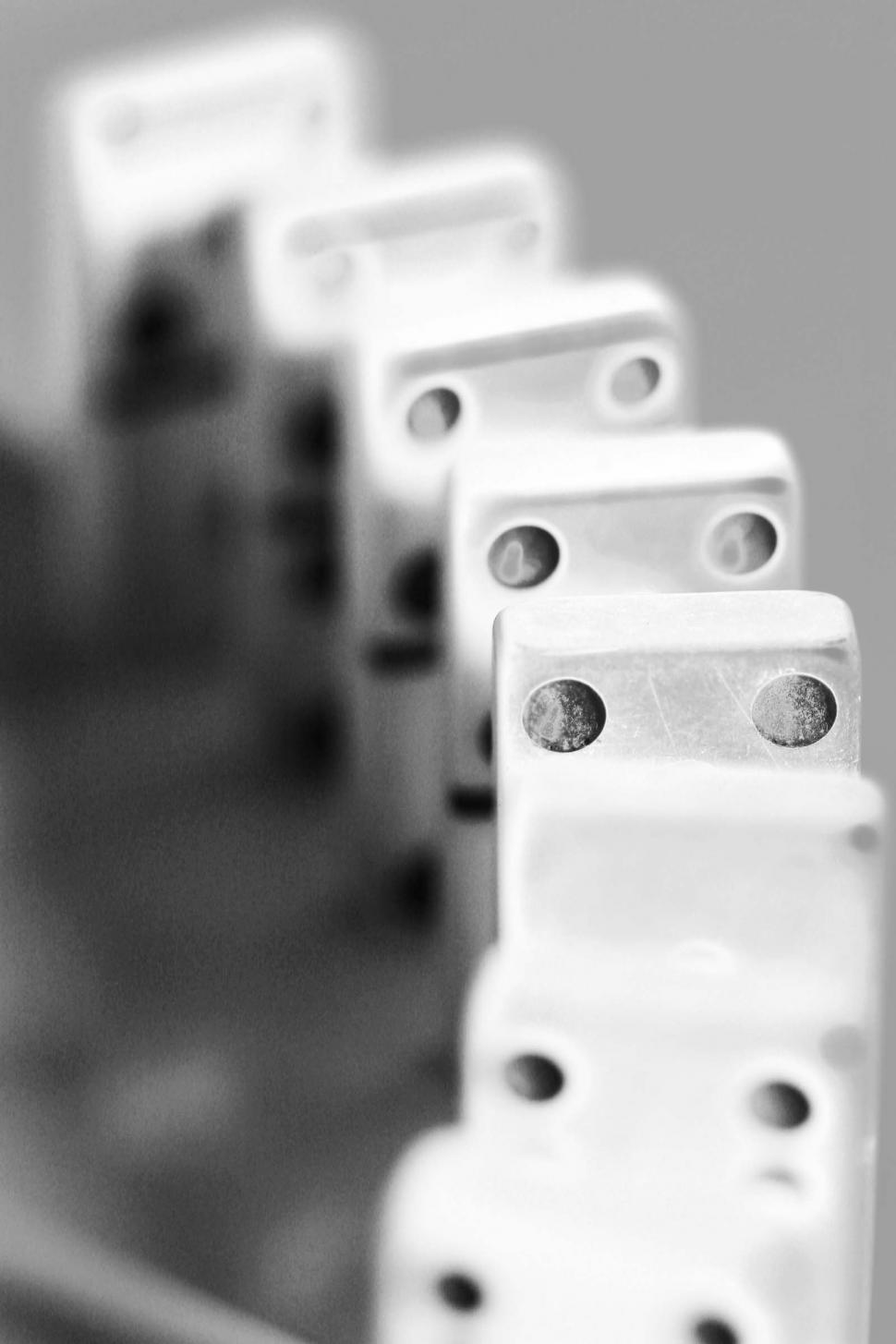 Download Free Stock Photo of dominos games sequence chain reaction falling precarious dots standing black and white glowing 