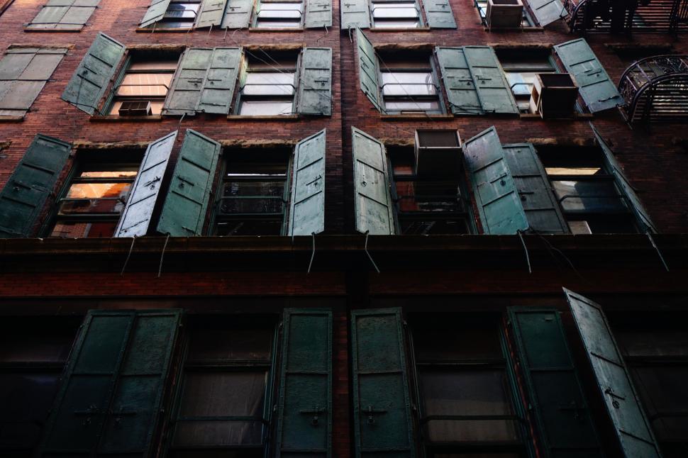 Free Image of Towering Building With Numerous Windows and Shutters 