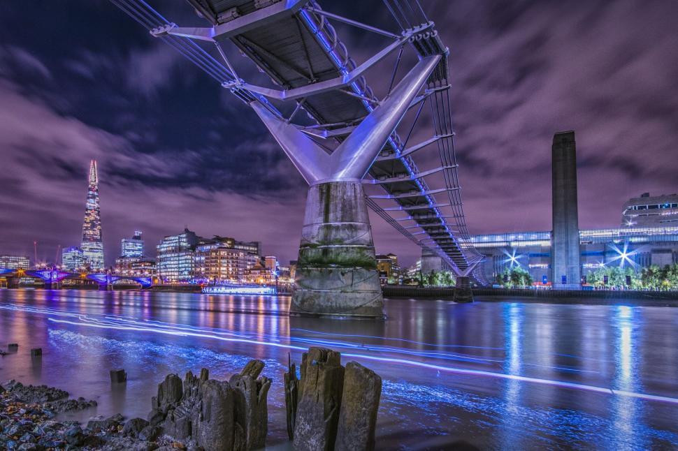 Free Image of Bridge Crossing River With Cityscape Background 