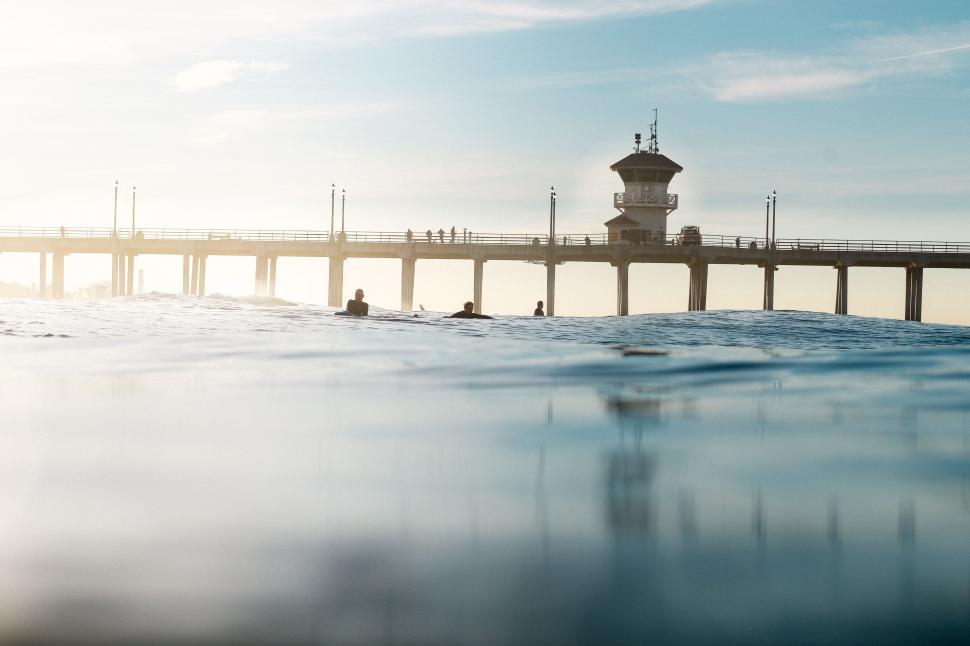 Free Image of People Swimming in the Ocean Near a Pier 