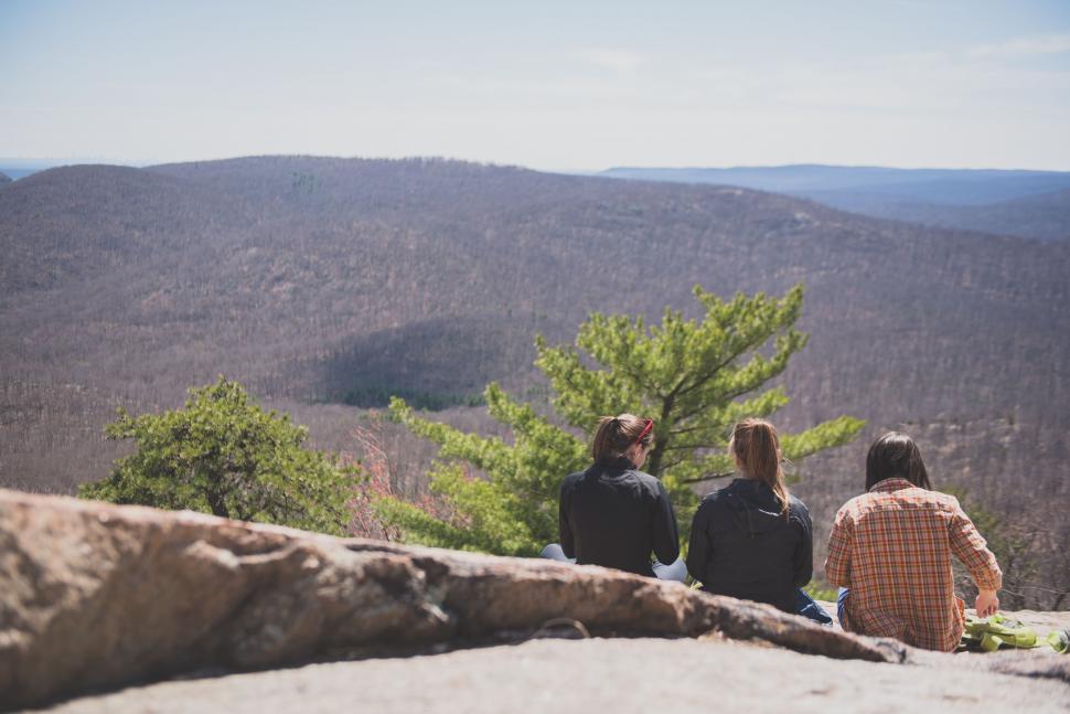 Free Image of Group of People Sitting on Top of a Mountain 
